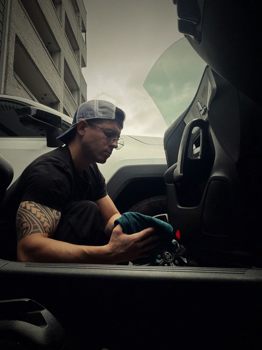 Roberto wiping down the door panel of the Mercedes