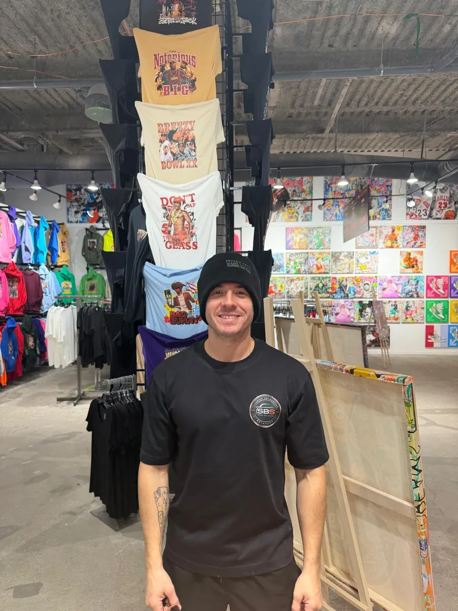 The owner wearing the Step By Step shirt